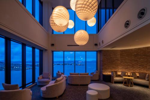 a lobby with couches and chairs and large windows at Tokyu Stay Hakodate Asaichi Akarinoyu in Hakodate
