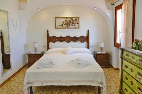 una camera da letto con un grande letto con due comodini di Case Vacanze La Conia a Cannigione