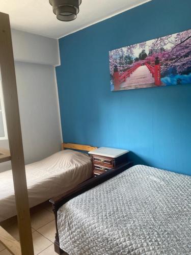 a bedroom with two beds and a blue wall at Apartment QUINTA DE AREIAS in Crespos