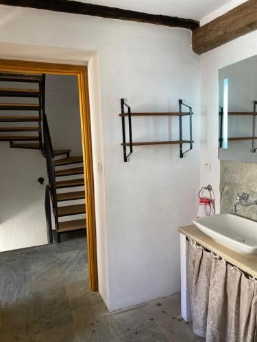 a bathroom with a sink and a mirror and a staircase at Borgo Village in Borgo