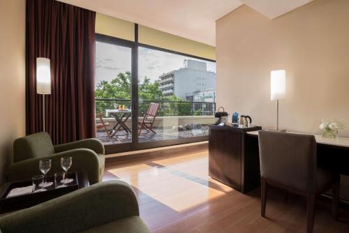 a living room with a view of a balcony at NH Mendoza Cordillera in Mendoza