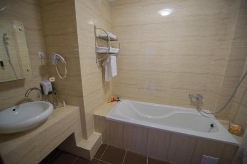 a bathroom with a bath tub and a sink at Lisova Pisnia Resort Hotel in Truskavets
