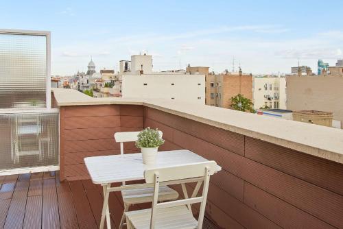 einen kleinen weißen Tisch und zwei Stühle auf dem Balkon in der Unterkunft NH Madrid Balboa in Madrid