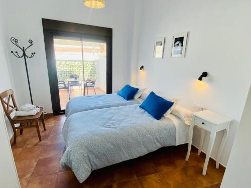 a bedroom with two beds and a table and chairs at Apartamentos rurales, La Casa de Baltasar in Fondón
