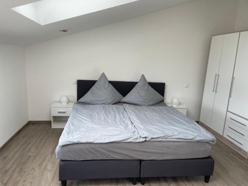 1 dormitorio con 1 cama grande y paredes blancas en Haus Schloßblick en Reichenberg
