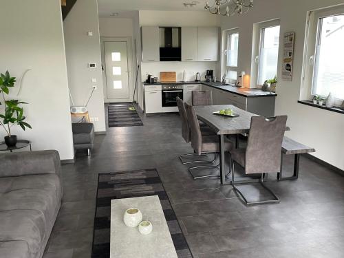 ein Wohnzimmer und eine Küche mit einem Tisch und Stühlen in der Unterkunft Haus Schloßblick in Reichenberg