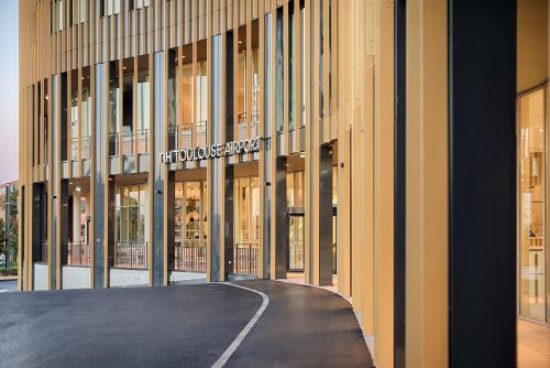 un edificio con un cartello sul lato di NH Toulouse Airport a Blagnac