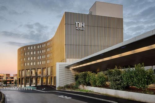 - un grand bâtiment avec un panneau hilton dans l'établissement NH Toulouse Airport, à Blagnac