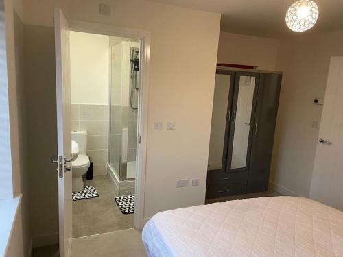 a bedroom with a bed and a bathroom with a shower at Fresh & Spacious New Build Home in Church Coppenhall