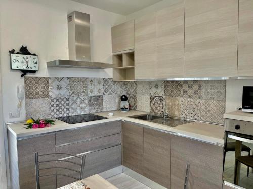 a kitchen with wooden cabinets and a sink and a stove at Casa Mac in La Ciaccia