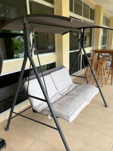 a swing bed on top of a porch at Nolan garden house in whitfield in Stratford