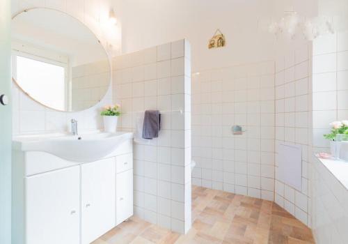een witte badkamer met een wastafel en een spiegel bij Atrium House - Netolice in Netolice