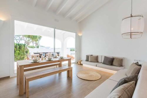 sala de estar blanca con mesa y sofá en Villas Etnia, en Binisafúller
