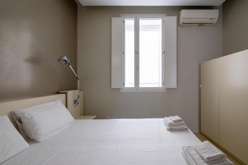 1 dormitorio con cama blanca y ventana en Residence i MasCa', en Bolonia