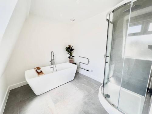 een witte badkamer met een wastafel en een douche bij Stylish & Spacious 4 Bed Coastal Haven in Weymouth in Weymouth