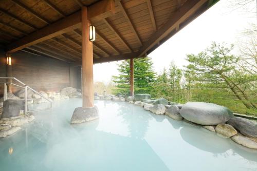 a pool of blue water under a building at FOURTREAT plus NASUKOGEN in Nasu