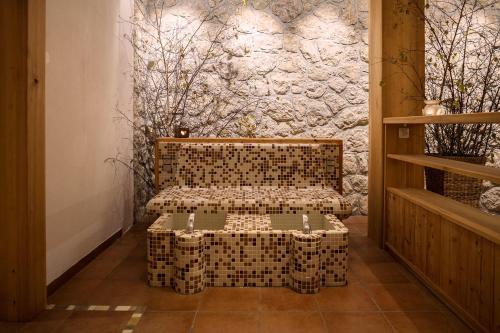 une chambre avec un banc en face d'un mur en pierre dans l'établissement Alpine Homestead, à Goreljek