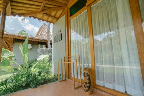 a house with a glass door with a balcony at Chandaka Borobudur in Magelang