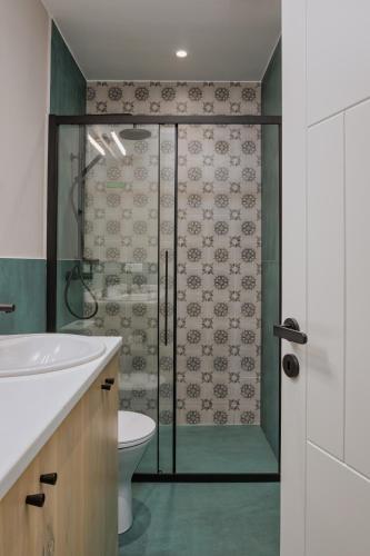a bathroom with a shower with a toilet and a sink at LozArt Traditional Stone House in Ellinikón
