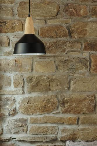 a black light hanging from a brick wall at LozArt Traditional Stone House in Ellinikón