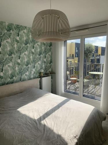 une chambre avec un lit et une grande fenêtre dans l'établissement Bel appartement, grande terrasse, à Boulogne-Billancourt