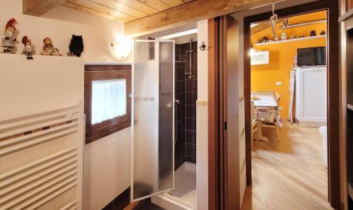 uma casa de banho com uma cabina de duche ao nível do chão ao lado de uma cozinha em Attic family apartment in center of Moggio em Moggio