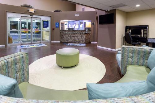 a waiting room with a table and chairs at Days Inn & Suites by Wyndham Cherry Hill - Philadelphia in Cherry Hill