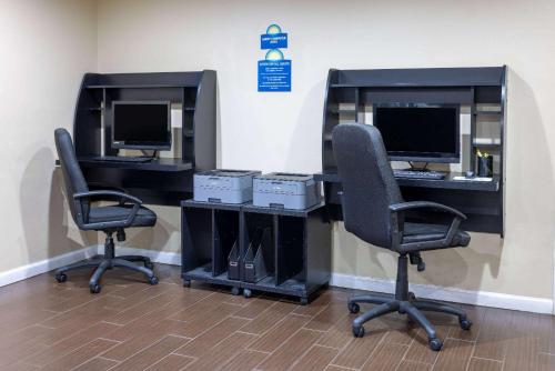 an office with two desks with two computer monitors at Days Inn & Suites by Wyndham Cherry Hill - Philadelphia in Cherry Hill