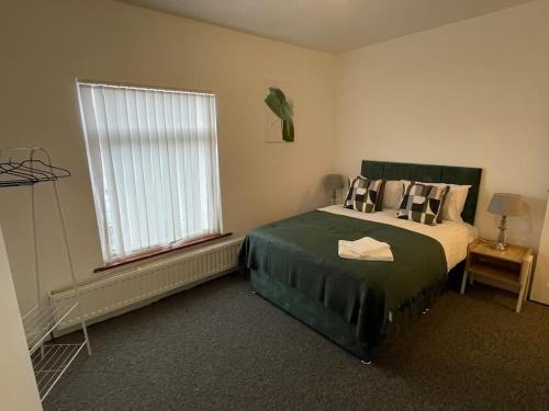 a bedroom with a large bed and a window at Cosy & Fresh Home in Stoke on Trent