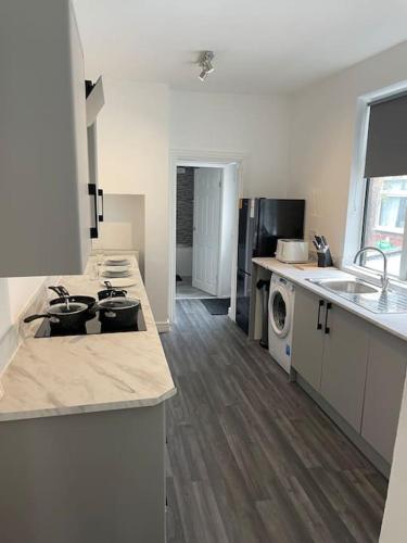 a kitchen with a sink and a dishwasher in it at Cosy & Fresh Home in Stoke on Trent