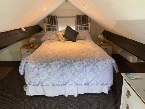 a bedroom with a bed in a attic at The Old Coach House in Penmaen-mawr