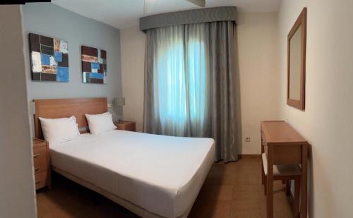 um quarto com uma cama branca e uma janela em Riviera del Mar apartment em Mijas Costa