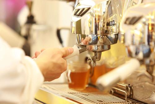 a person is making a drink in a juicer at Ramada Encore by Wyndham CheonAn in Cheonan