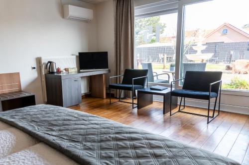 sypialnia z łóżkiem, 2 krzesłami i biurkiem w obiekcie Hotel Rooms w mieście Breskens