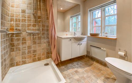 a bathroom with a shower and a toilet and a sink at Cozy Home In Hishult With Kitchen in Knäred