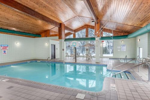 una gran piscina en un edificio con techo de madera en AmericInn by Wyndham New Richmond, en New Richmond