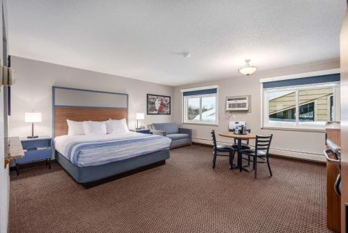a hotel room with a bed and a table and chairs at AmericInn by Wyndham New Richmond in New Richmond