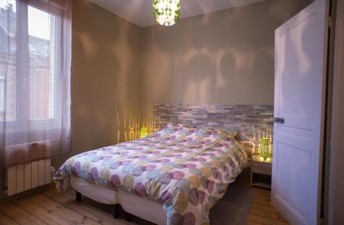 亞眠的住宿－Gite Amiens，一间卧室配有一张床和一个吊灯