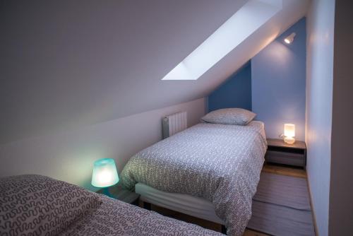 two twin beds in a room with two lights on at Gite Amiens in Amiens