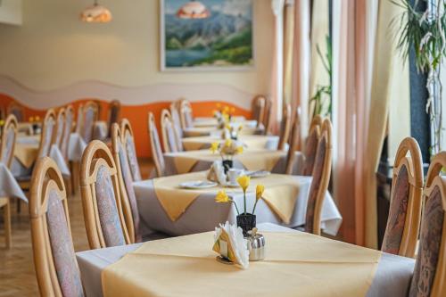 a row of tables in a restaurant with yellow flowers on them at Wanta in Zakopane