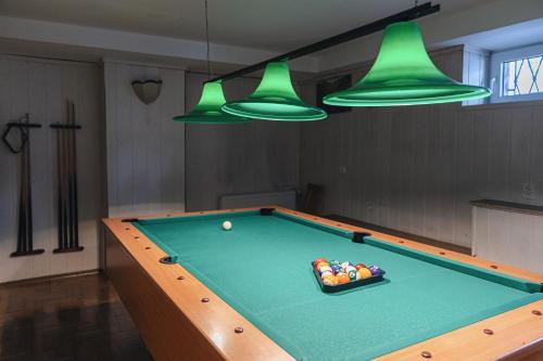 a pool table in a room with green lights at Wanta in Zakopane