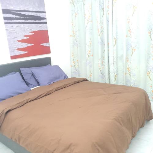 a bed with a brown blanket and blue pillows at KuantanBukitSetongkolArea3R2B.HTAA/TOWN-5min only in Kuantan