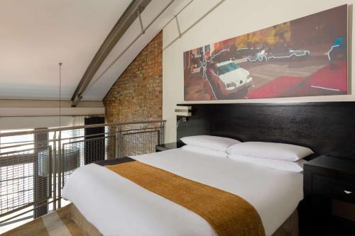 um quarto com uma cama e um quadro na parede em Garden Court Victoria Junction em Cidade do Cabo