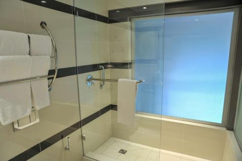 a bathroom with a shower with a glass door at Garden Court Victoria Junction in Cape Town