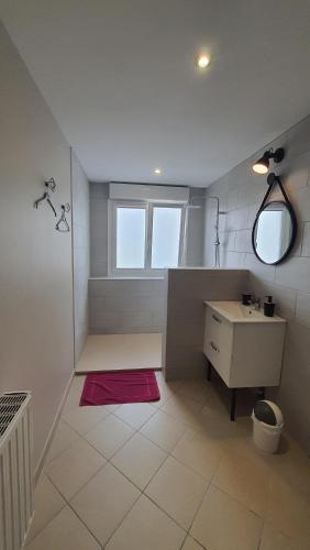 une salle de bain blanche avec un lavabo et un miroir dans l'établissement Maison Napoléon, à Wimille