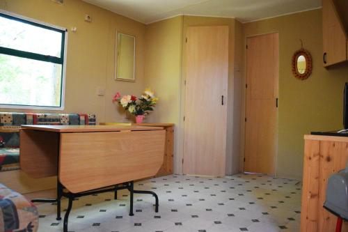 um quarto com uma secretária e uma porta com um vaso de flores em SAFARI CAMPING em Pombia