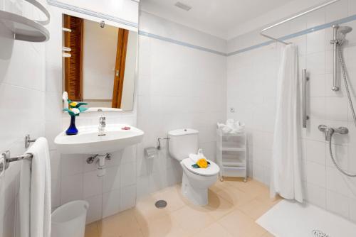 a white bathroom with a toilet and a sink at Spa & Sport Hotel Mar y Sol in Arona