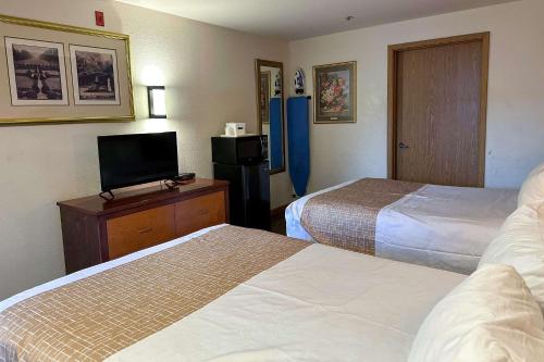 a hotel room with two beds and a flat screen tv at Econo Lodge Edmonds North Seattle in Edmonds