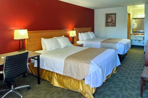 a hotel room with two beds and a desk at Econo Lodge Edmonds North Seattle in Edmonds