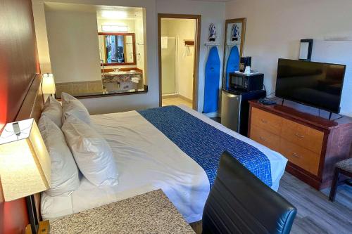 a hotel room with a bed and a flat screen tv at Econo Lodge Edmonds North Seattle in Edmonds